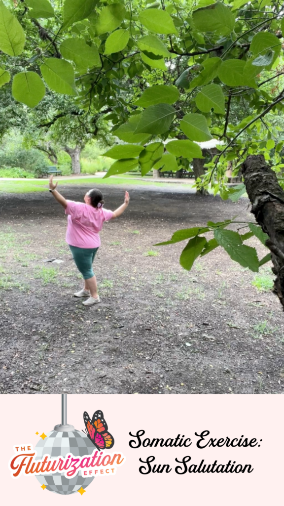 Alexandra, a somatic practitioner and founder of Flutura Creative, is seen in an open field leading a restorative and grounding somatic exercise. She stands tall with arms raised towards the sky, embodying the Fluturization Sun Salutation amidst a backdrop of lush trees and an expansive sky.